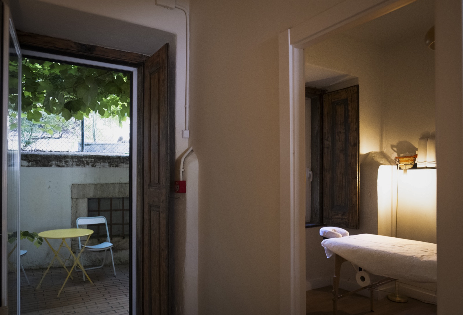 A treatment room seen from the corridor, with the patio door open